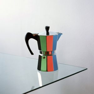 Moka pot reflecting green, red and blue paper